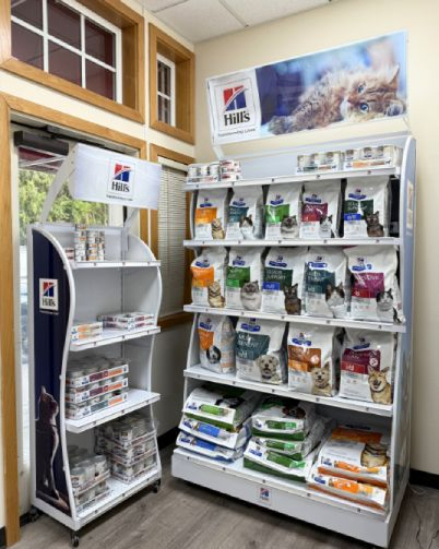 Shelves stocked with various brands of pet food in a store.